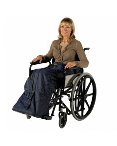 Een glimlachende vrouw zit behaaglijk en warm in haar rolstoel. Ze heeft het waterdichte Wheely Cosy rolstoel deken aan waardoor ze droog en warm zit. Ze is blij want hierdoor kan ze de deur uit met slecht weert. De kleur is blauw. De rits zit aan de voor
